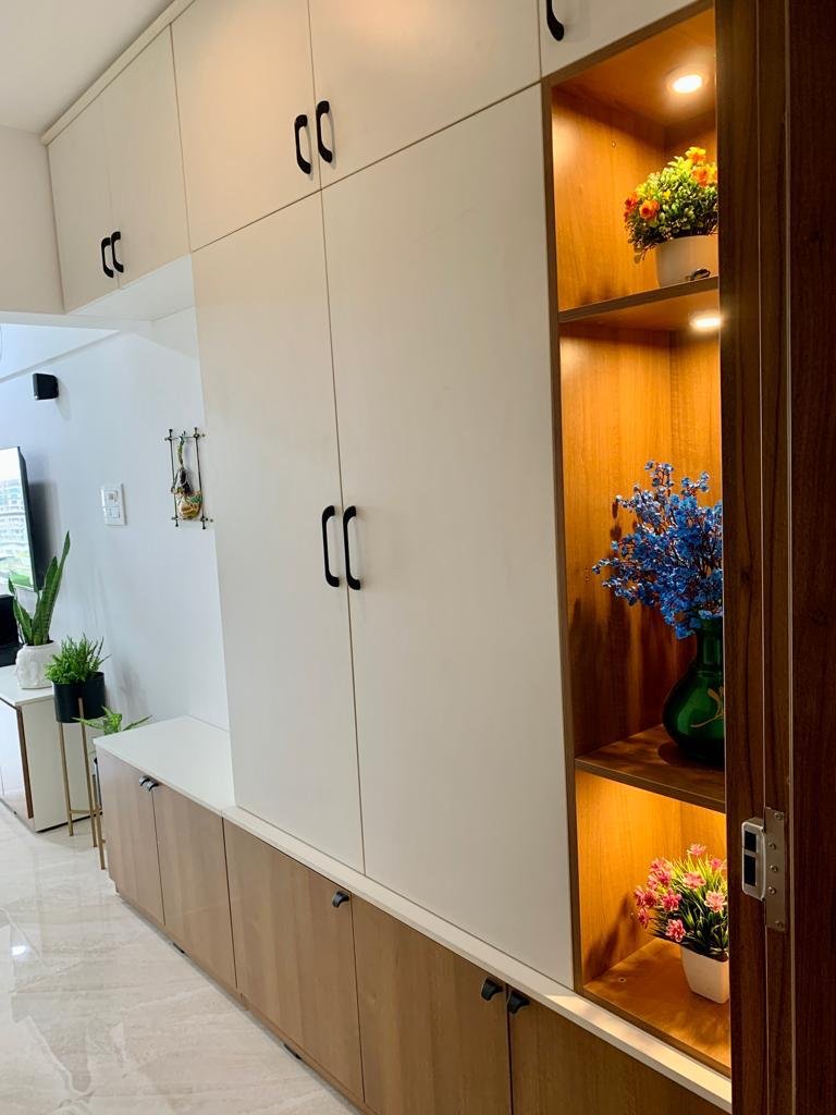 Cream wardrobe wall with a lit wooden display shelf