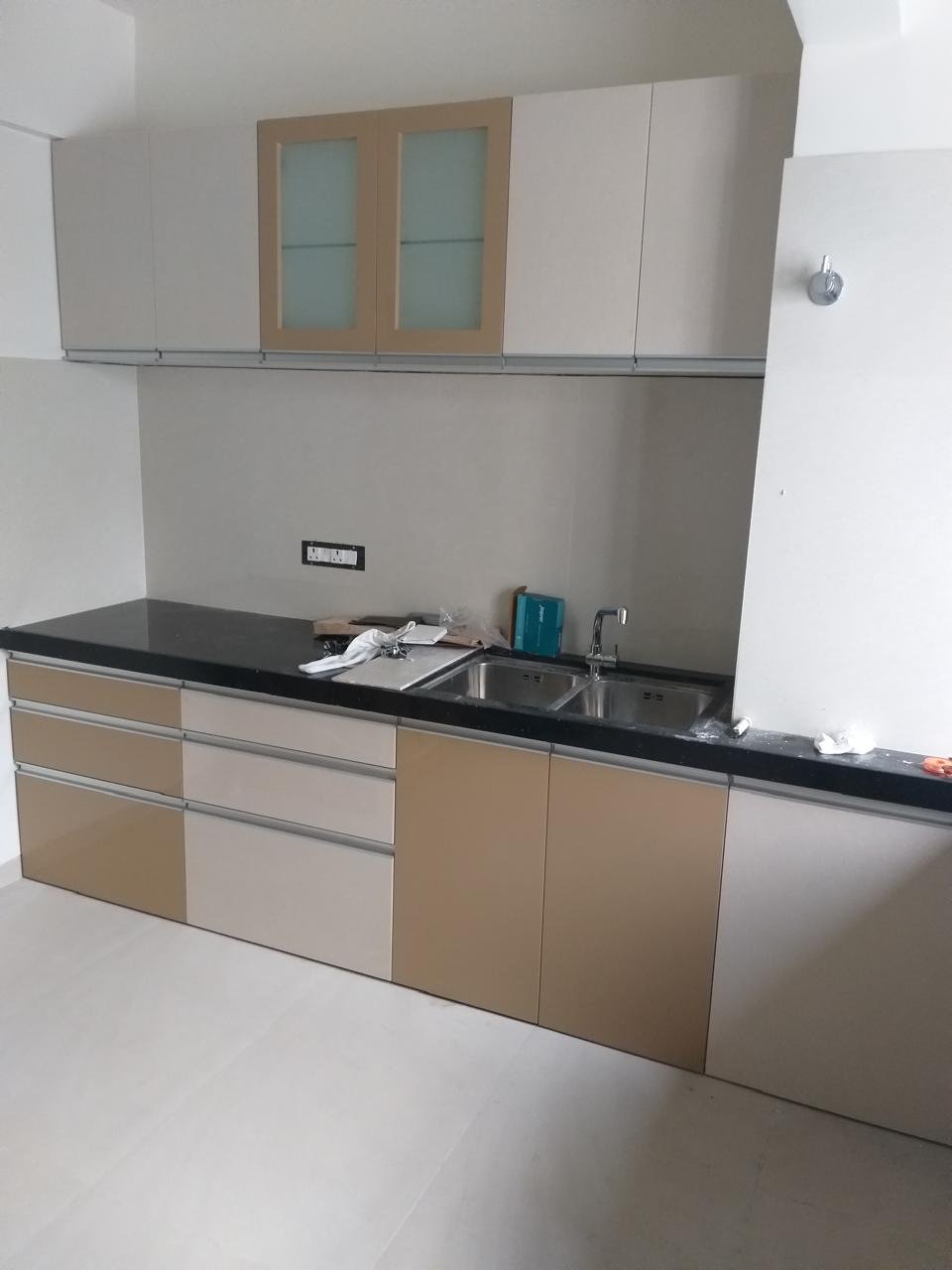 Modular kitchen in beige and white with a black countertop and double sink