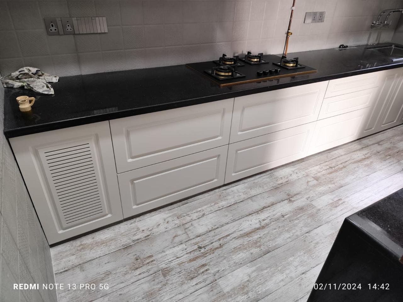 Parallel modular kitchen in white shaker style with a black granite countertop