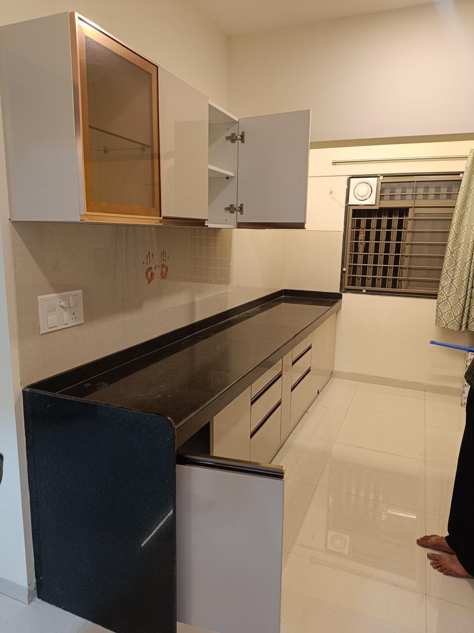 Parallel modular kitchen in cream with a black granite countertop