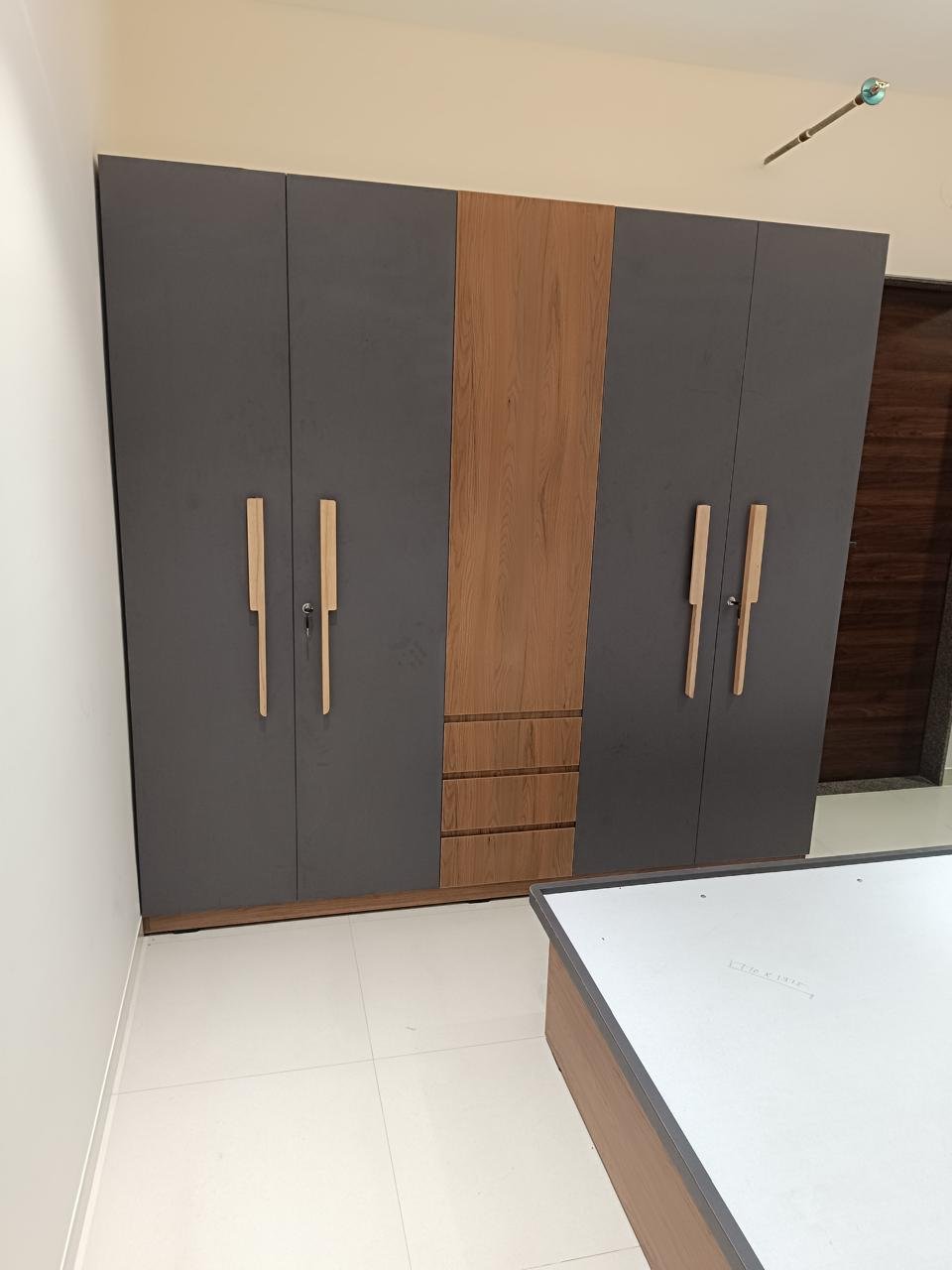 Wide multi-door wardrobe in charcoal and wood finishes with three central drawers