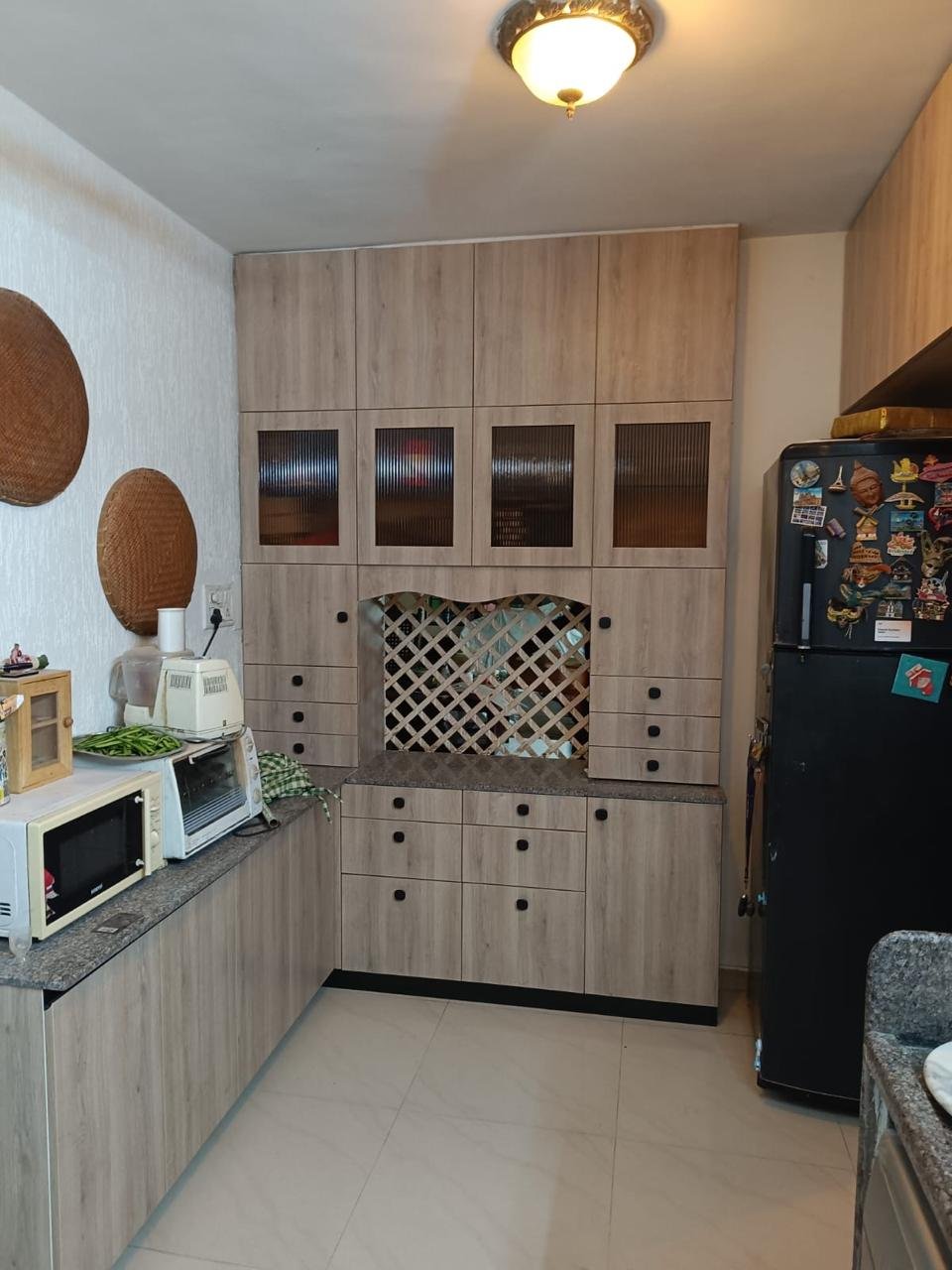 Kitchen storage wall in wood-finish laminate with a lattice display alcove