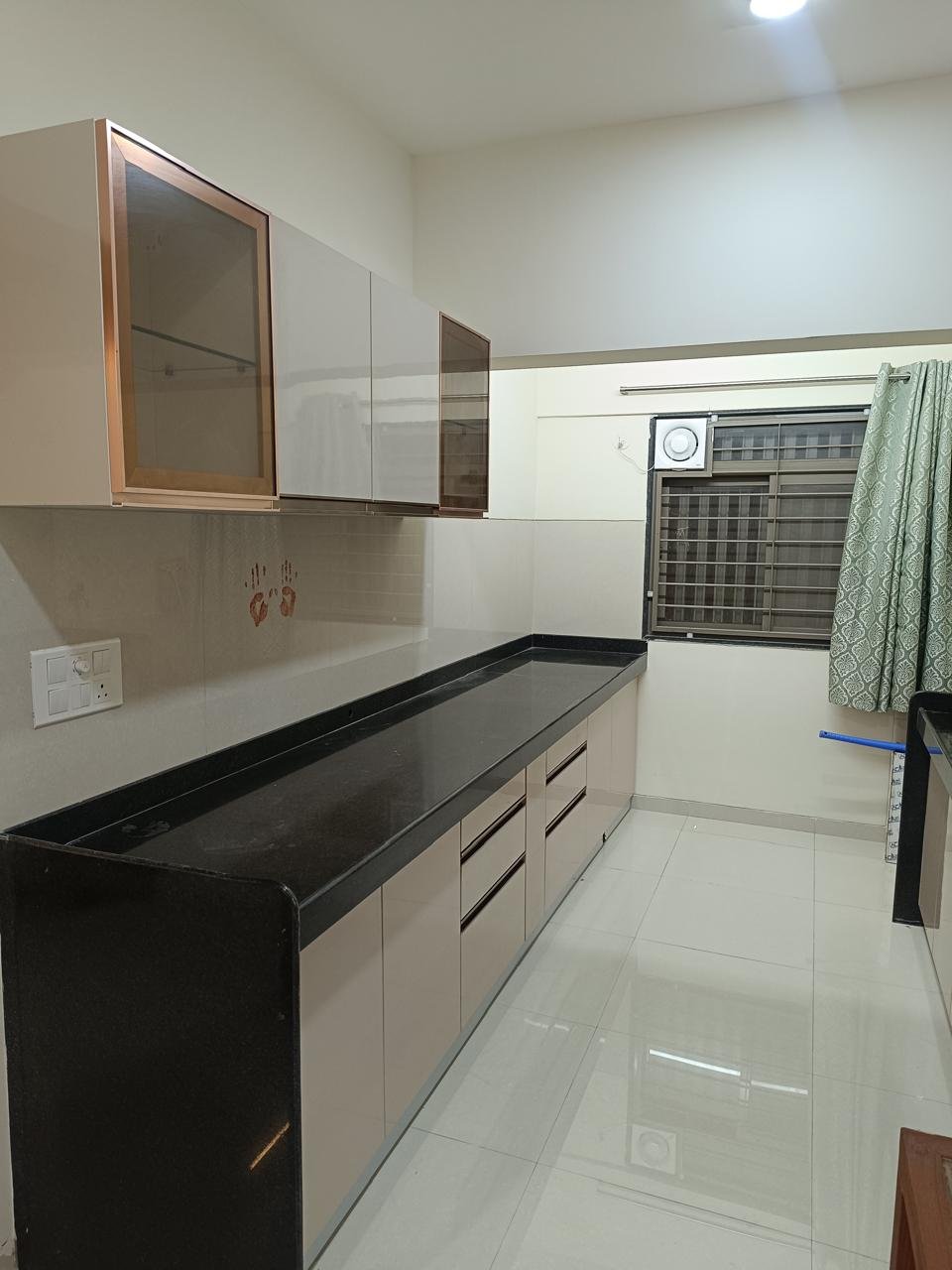 Parallel modular kitchen in cream with bronze-framed glass wall cabinets